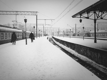 People walking on railroad station platform in winter
