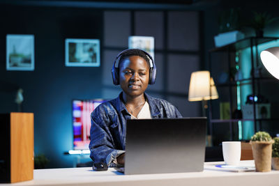 Portrait of young woman using laptop at office