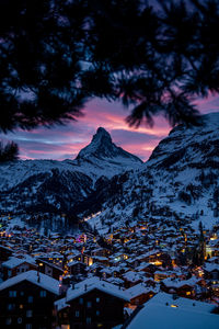 Illuminated buildings against sky at dusk during winter