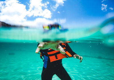 Water surface shot of man in swimming pool against sky