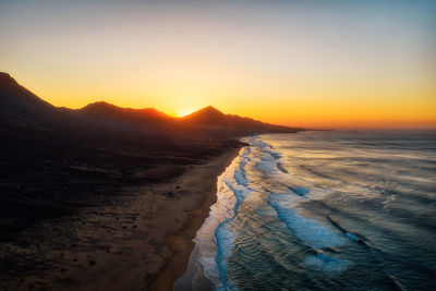 Scenic view of sea against clear sky during sunset