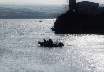 Silhouette boat sailing in sea against sky