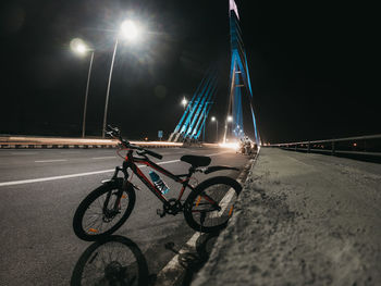 Bicycle parked on road at night