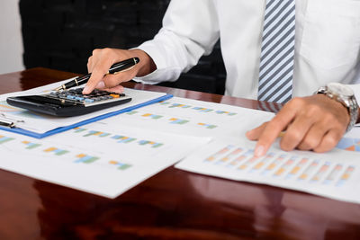 Midsection of businessman working at desk in office