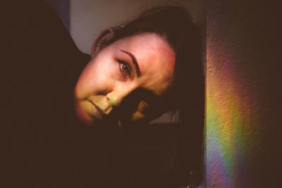 Person staring at camera with rainbow light over face