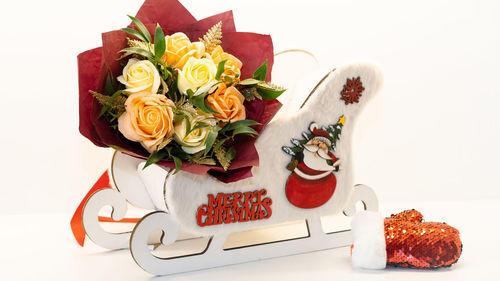 Close-up of roses on table against white background