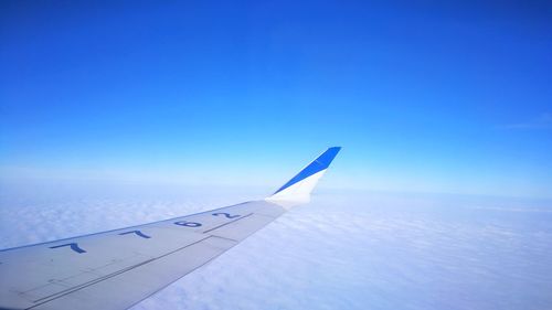 Close-up of airplane wing against clear blue sky