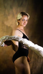 Portrait of young woman standing against sky