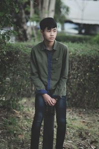 Young man looking away while standing on land