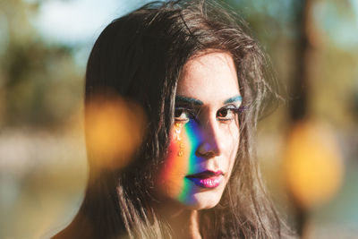 Close-up portrait of beautiful woman with colorful face paint