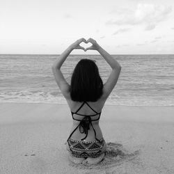 Rear view of woman with umbrella on beach