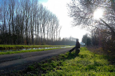 Man walking on field against sky