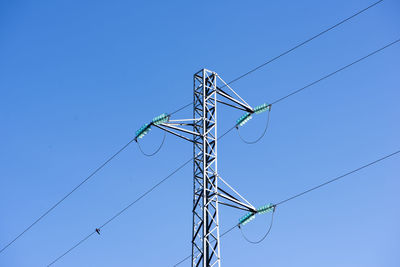 Low angle view of electricity pylon against clear sky