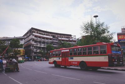 Cars on road in city against sky