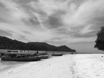 Boats moored on shore against sky