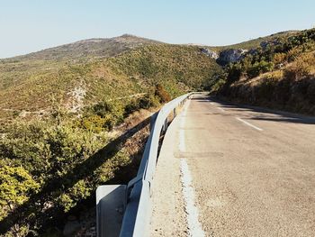 Road by mountain against clear sky