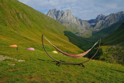 Scenic view of green landscape and mountains against sky