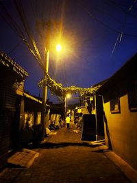 Man walking on illuminated road at sunset