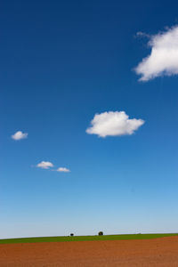 Scenic view of field against blue sky