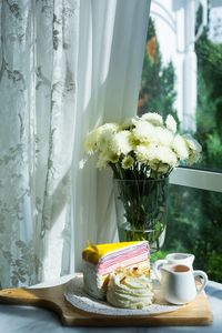 Flower vase on table by window