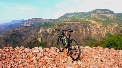 Bicycle on mountain against sky