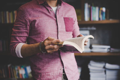 Midsection of man holding book