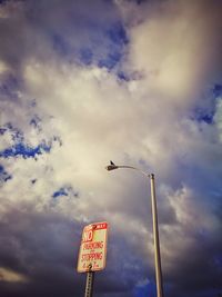 Low angle view of street light against cloudy sky