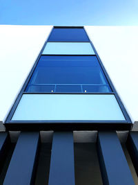 Low angle view of modern building against clear blue sky