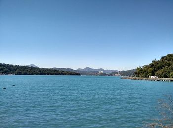 View of calm sea against clear blue sky