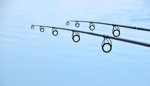 Low angle view of fishing rods against sky