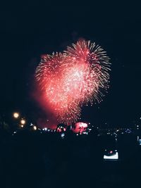 Low angle view of firework display at night