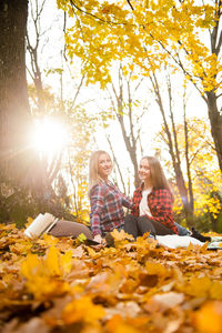 People sitting on leaves during autumn