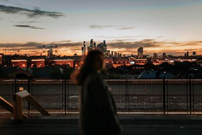 Illuminated cityscape against sky during sunset