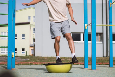 Professional athlete performs a squat with his own weight on a balance apparatus for intense workout