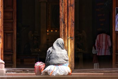 Rear view of woman walking in temple outside building