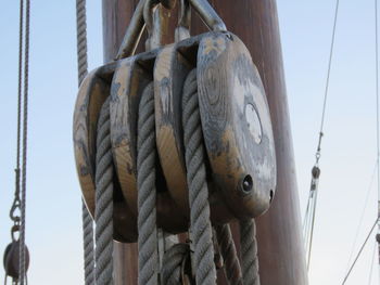 Low angle view of ropes on pulley by mast