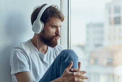 Portrait of young man using mobile phone while sitting outdoors