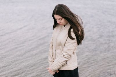 Beautiful young woman standing in water