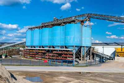 Big blue metallic industrial silos for the production of cement at an industrial cement plant