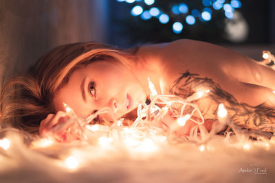 Portrait of young woman with illuminated candles