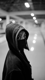 Portrait of woman standing against illuminated lighting equipment