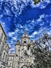 Low angle view of bell tower against cloudy sky