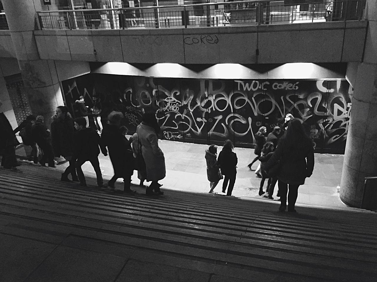 large group of people, person, men, architecture, built structure, lifestyles, walking, building exterior, city life, leisure activity, city, mixed age range, street, steps, shadow, sunlight, medium group of people, outdoors, railing