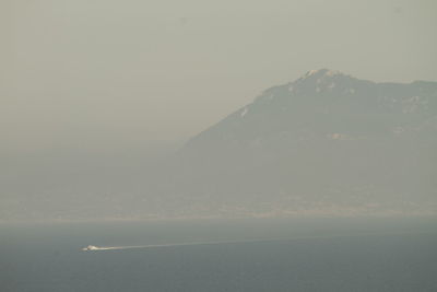 Scenic view of sea and mountains against sky