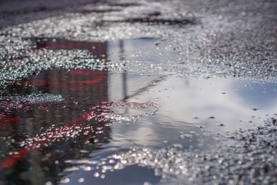 Reflection of umbrella on puddle in lake during rainy season