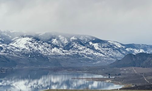 Scenic view of lake and snowcapped mountains against sky