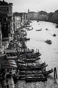 Gondolas moored in grand canal amidst building on sunny day