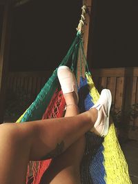 Low section of woman relaxing in hammock at night