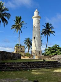 Lighthouse by sea against sky