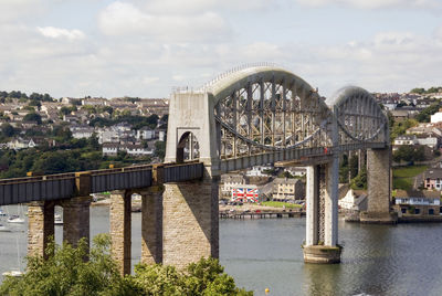 Bridge over river in city against sky